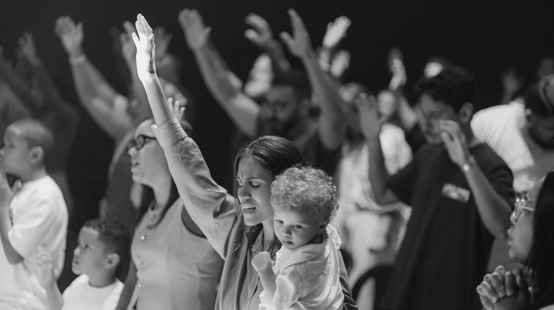 Famílias reunidas em adoração durante um culto da Doxa